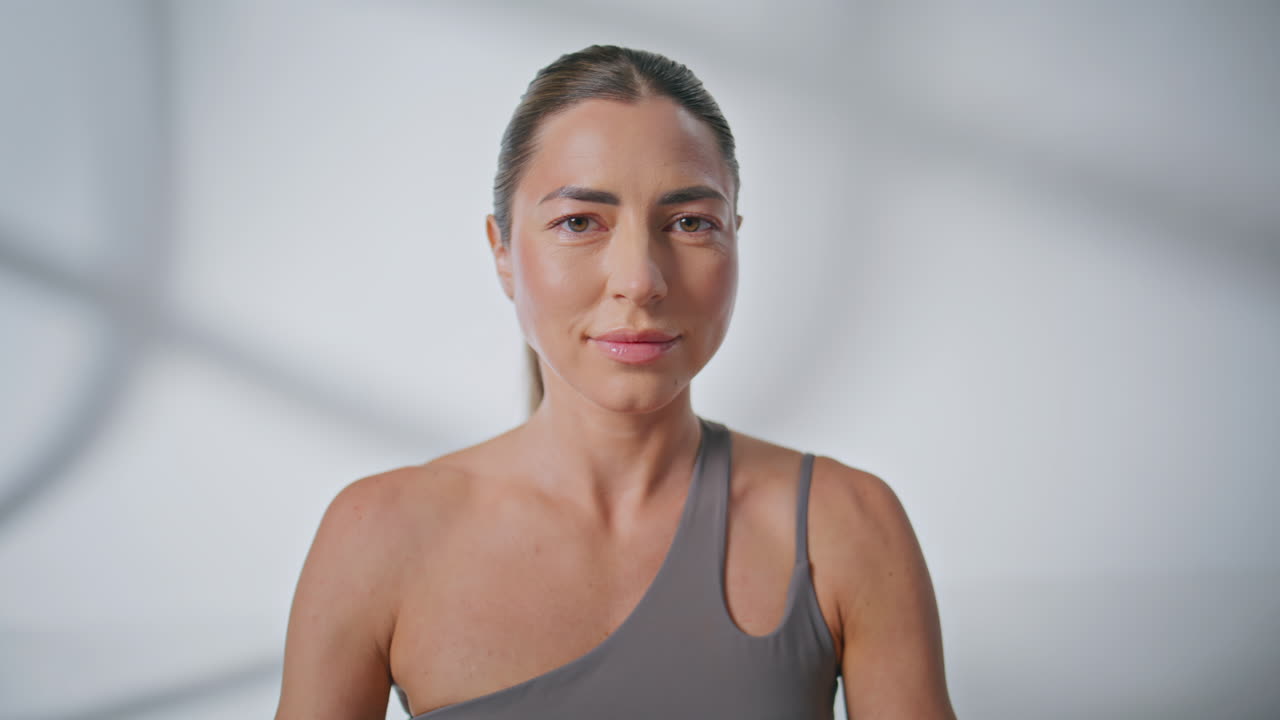 Closeup breathing girl meditating studio in morning. Woman looking at camera