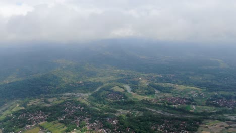 vast terrain with fields, forests and villages in indonesia, aerial drone view