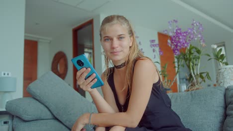woman holding phone on a couch in a living room