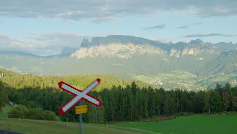 Sheer-rocky-cliffs-shaded-by-clouds-stand-prominent-over-lush-green-valley