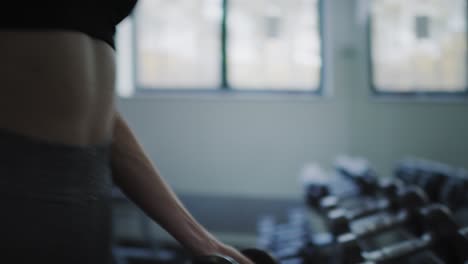 Handheld-view-of-female-athlete-practicing-with-dumbbell