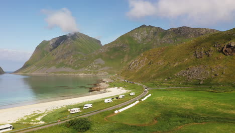 flyover aerial footage of vik beach and hauklandstranda norway, with rv's on the coastline, drone shot following the highway