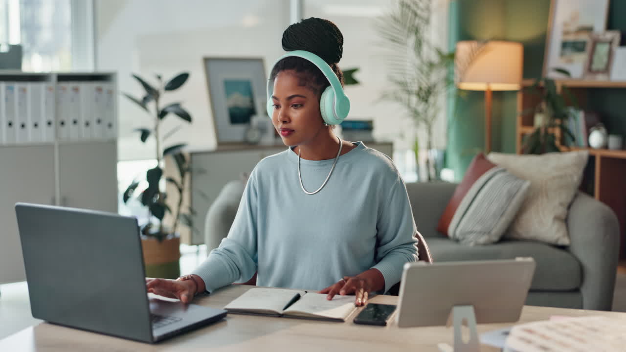 Woman working from home with laptop and headphones