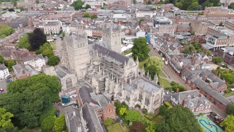 Orbital-view-of-Exeter-city-featuring-the-cathedral-under-repair-amidst-a-blend-of-historic-and-modern-structures,-Devon,-UK