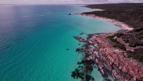 Fliegen-Sie-In-Der-Luft-Entlang-Der-Küste-Des-Kristallklaren-Türkisfarbenen-Wassers-Und-Der-Orangefarbenen-Felsen-Von-Castle-Rock,-Westaustralien