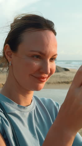 woman taking a photo at the beach at sunset