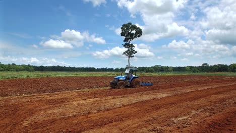 agricultor que trabaja conduciendo un tractor aislado arando campos en upala en costa rica