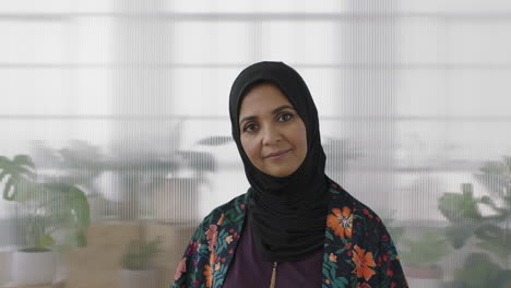 portrait of senior muslim business woman smiling looking confident at camera wearing traditional headscarf mature experienced female in office workspace