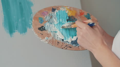 The-Hands-Of-An-Unrecognizable-Girl-Mixing-Colors-On-The-Painter's-Palette