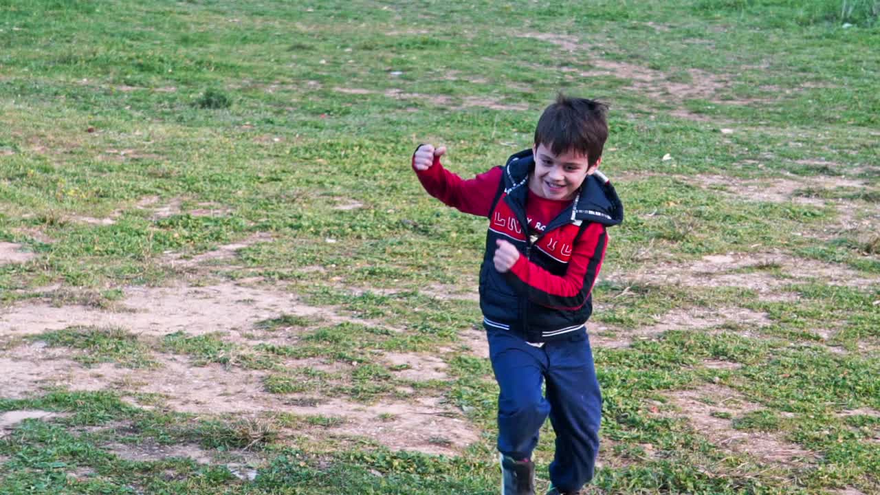 cámara lenta de lindo niño caucásico corriendo en los campos hacia la cámara 120fps