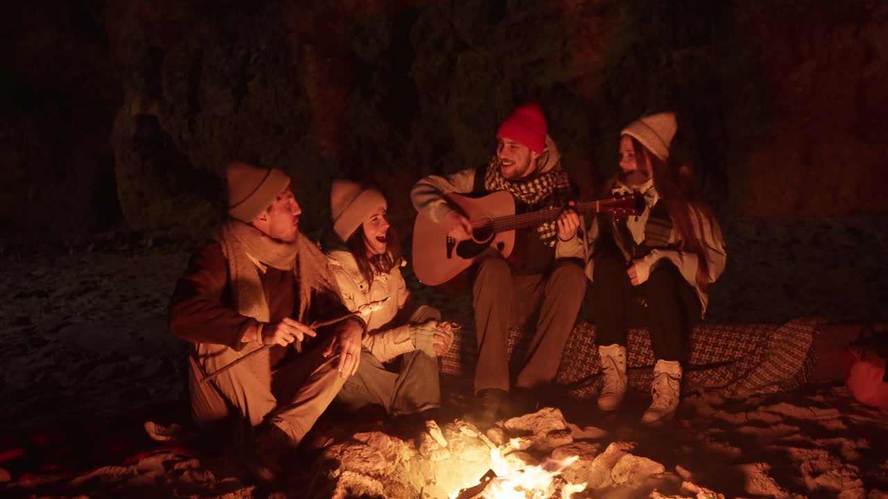 Friends Singing Around a Campfire on the Beach at Night