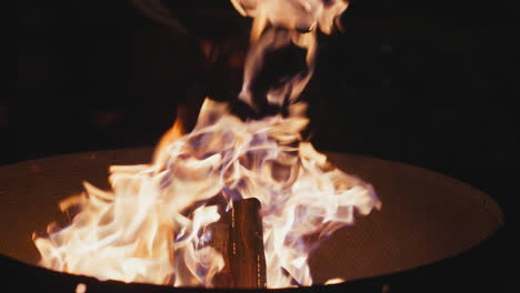 firewood burning in steel cauldron late at night. bonfire provides comforting light and warmth during late-night hours. crackling of firewood creating serene atmosphere