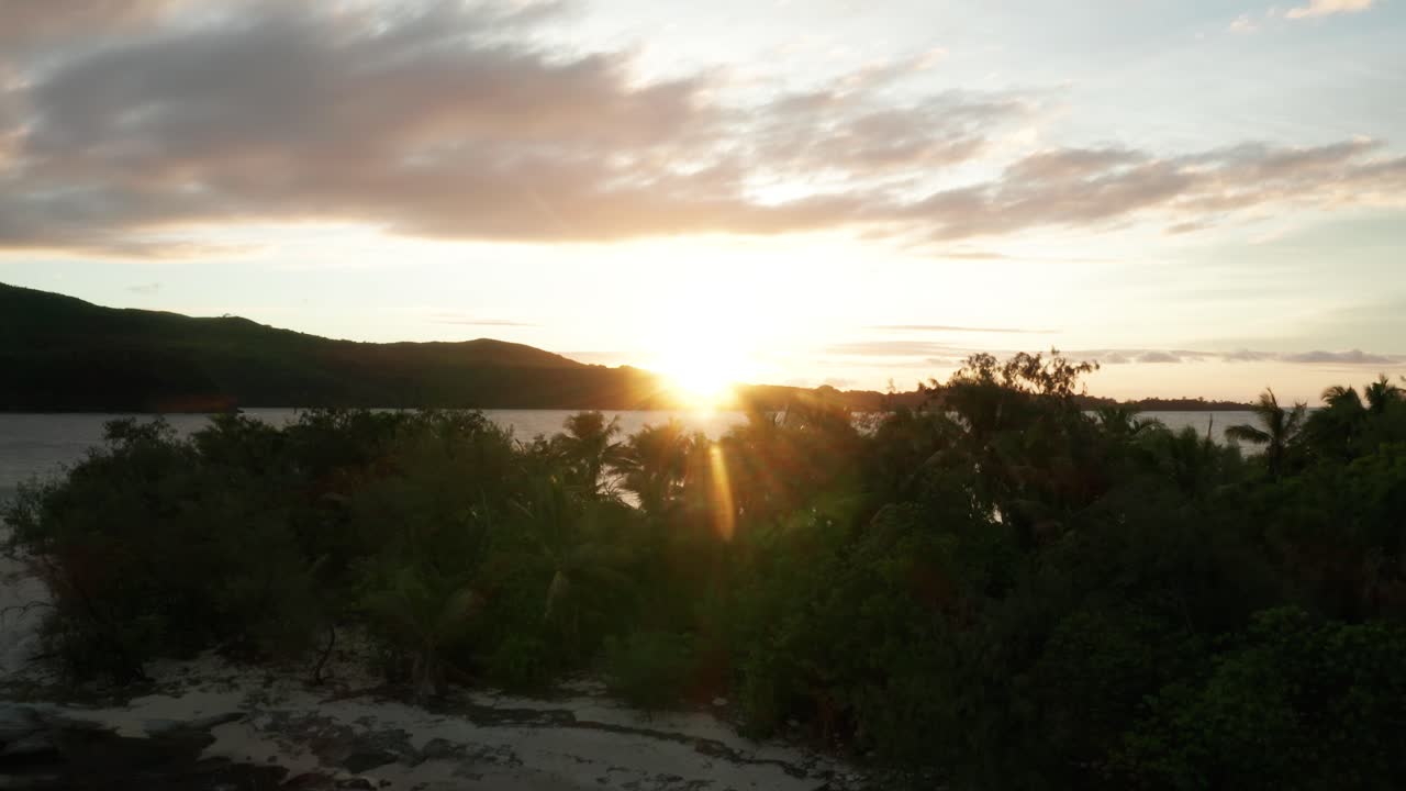 el impresionante paisaje de un mar tranquilo y pacífico con árboles verdes durante el amanecer en fiji - toma aérea