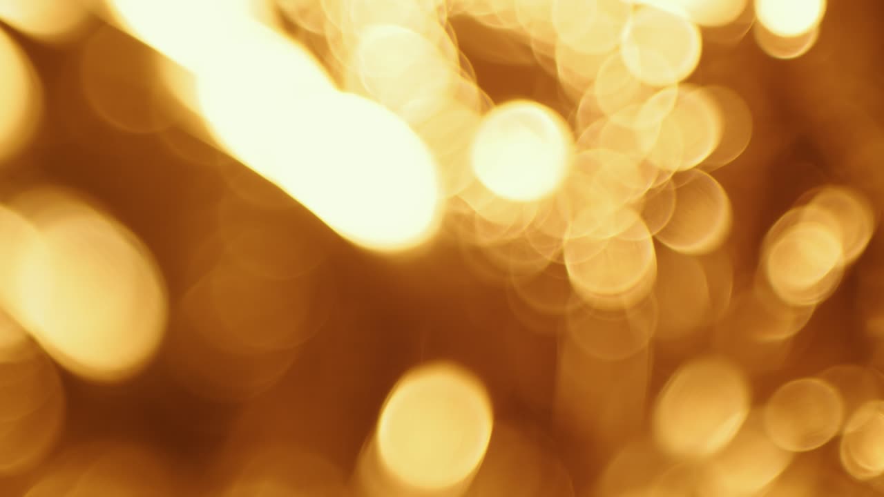 Warme goldene Bokeh-Kreise bewegen sich auf dunklem Hintergrund