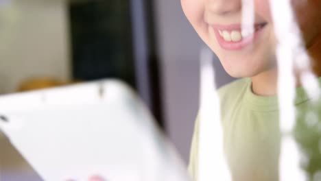 Boy-using-digital-tablet-in-kitchen