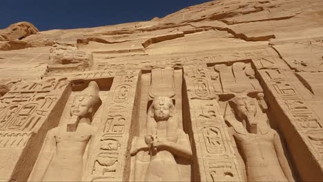detailed close-up view of the monumental statues and hieroglyphic inscriptions at the abu simbel temple in egypt. carved into sandstone, these ancient figures represent pharaoh ramesses ii.