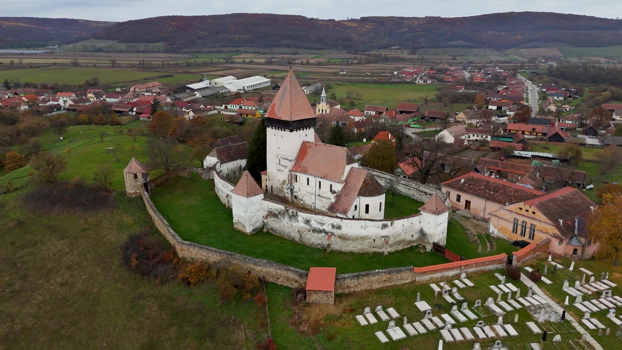 Dron elegantně krouží kolem kostela a nabízí 360stupňový pohled na jeho středověkou architekturu, opevněné zdi a úchvatnou podzimní krajinu, která ho obklopuje.