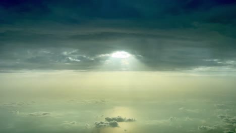 awesome aerial cockpit view of a dark and cloudy sky with a gap and sunbeam through the hole