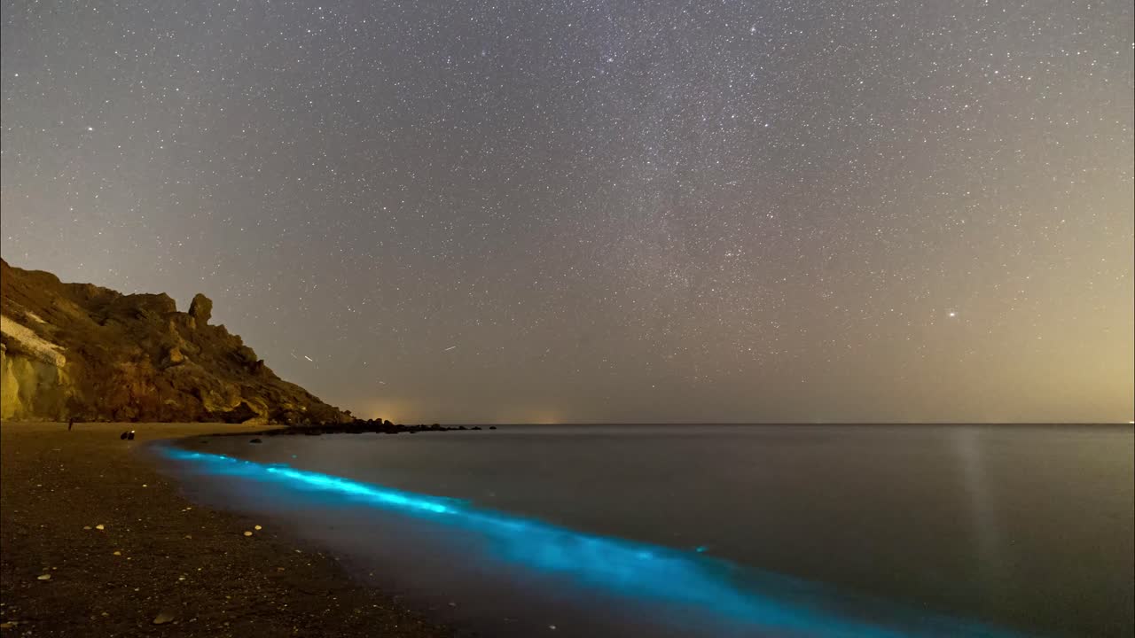 cielo nocturno lleno de estrellas y fitoplancton de color azul brillando en cada ola del mar en el golfo arábigo pérsico en oriente medio escénico maravilloso hermoso efecto fenomenal criatura marina paisaje de playa