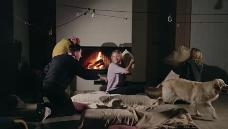 friends having a pillow fight by the fireplace