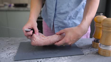 woman preparing chicken breast