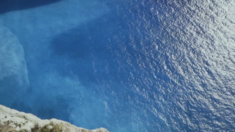 guardando giù massiccia parete rocciosa all'acqua blu smeraldo su zante grecia