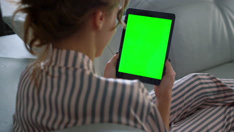 Girl-using-green-tablet-resting-on-sofa-closeup.-Businesswoman-talk-team-at-home