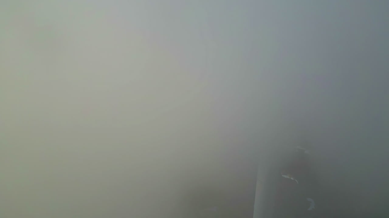 Aerial fly through smoke stack of dense cloud from industrial plant on city outskirts