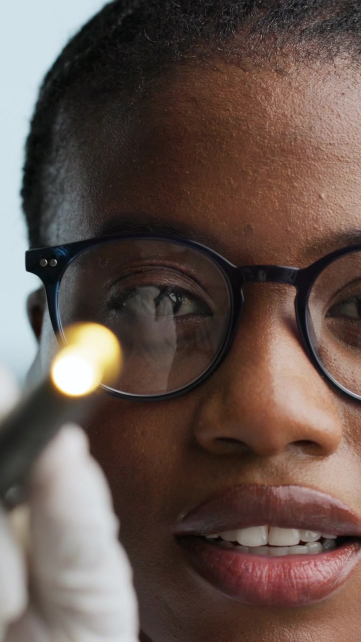 Optometrist Examining Patient Eye with Penlight