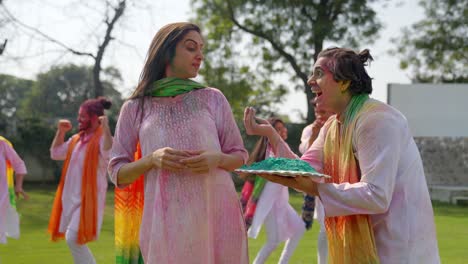 indian man surprising his wife with holi colors