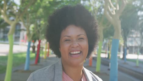 Portrait-of-happy-plus-size-biracial-woman-smiling-in-park