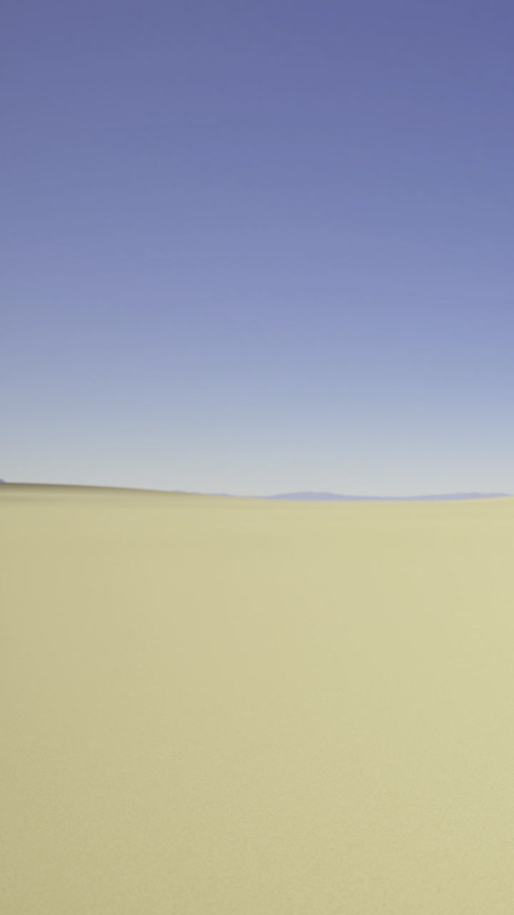 Vasta pianura aperta sotto un cielo azzurro chiaro in un paesaggio lontano.
