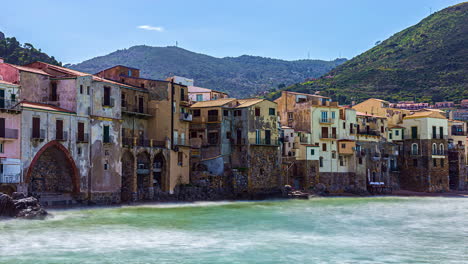 View-of-residentail-bbuildings-in-Puritate-Beach-in-Salento,-Apulia,-Italy-with-waves-crashing-on-the-beach-in-timelapse