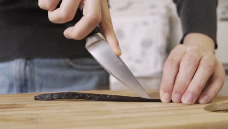 cortando un palito de vainilla en una tabla de cortar