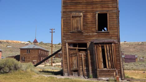 un edificio antiguo está apuntalado por un poste en la ciudad fantasma de bodie california