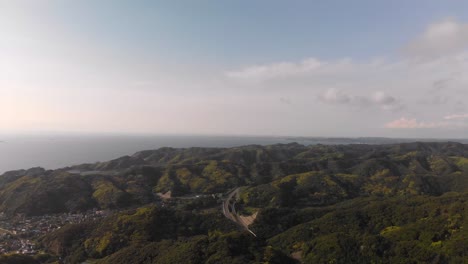 Volando-Sobre-Las-Verdes-Montañas-Costeras-Al-Atardecer