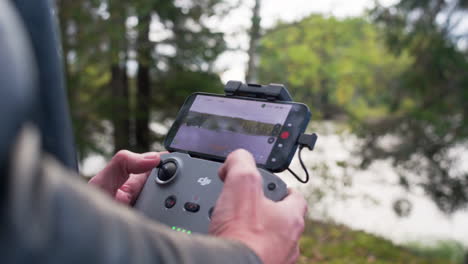Caucasian-man-operating-a-drone-on-a-remote-controller-in-a-the-nature