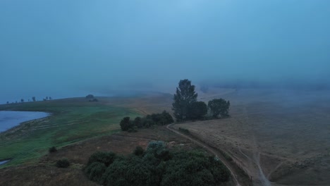 Nanclares-de-gamboa-in-basque-country,-misty-morning-over-serene-landscape,-dawn's-light,-aerial-view