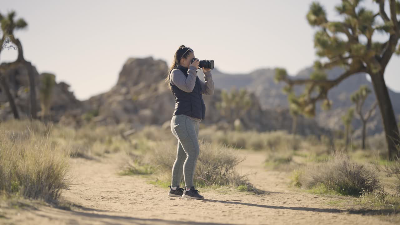 Pige fotograferer Joshua Tree Nationalpark-ørkenen i Californien med et Sony A1 kamera – bredt skud af pige i landskab