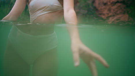 woman hands playing water turquoise lagoon closeup. unknown lady emerald fjord