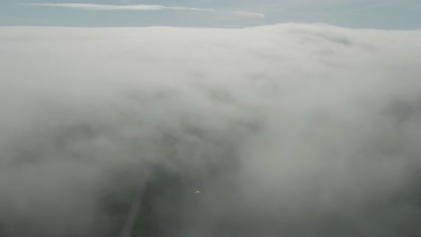 aerial tilt reveal shot of blue sky above gray clouds in magdalen islands