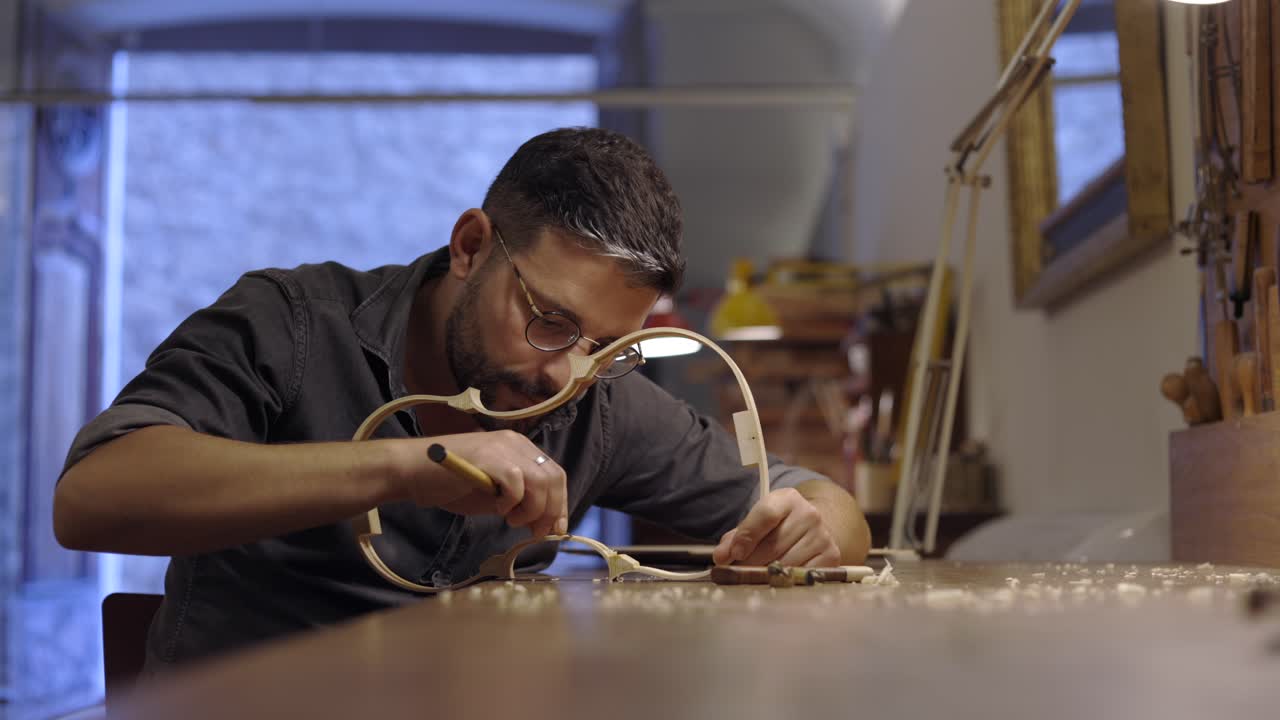 luthier creando costillas de violín en el taller