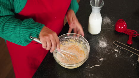 at christmas, whisking batter in kitchen, preparing holiday treats with milk and utensils