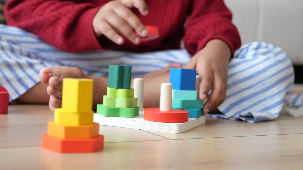 Child Playing with Wooden Stacking Toys