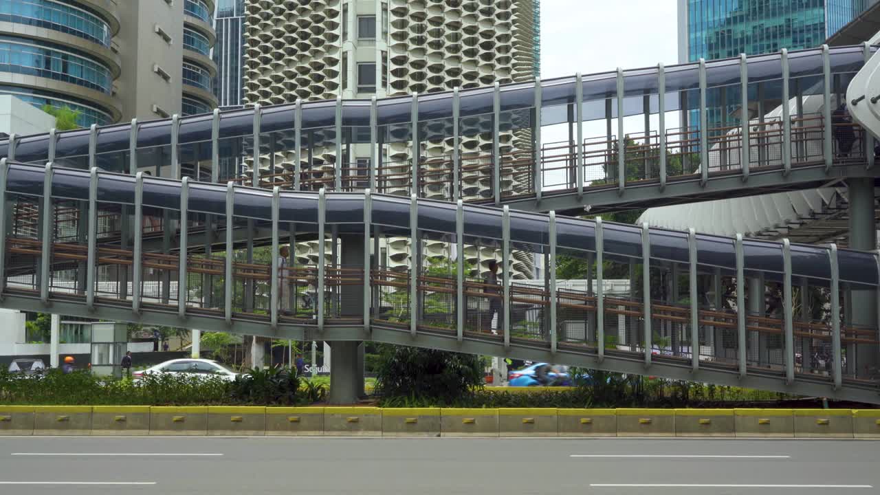 사람들은 버스 정류장을 향해 다리 위를 고 있습니다.