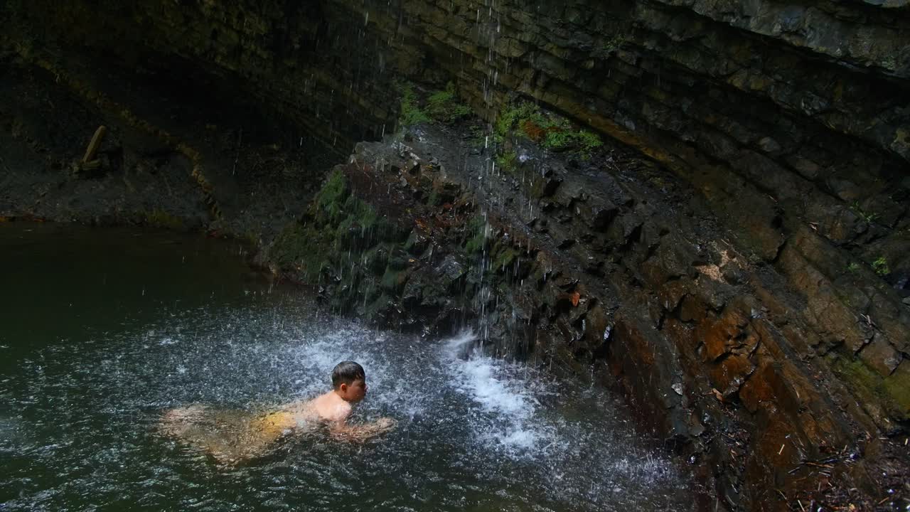 폭포 에서 수영하는 소년