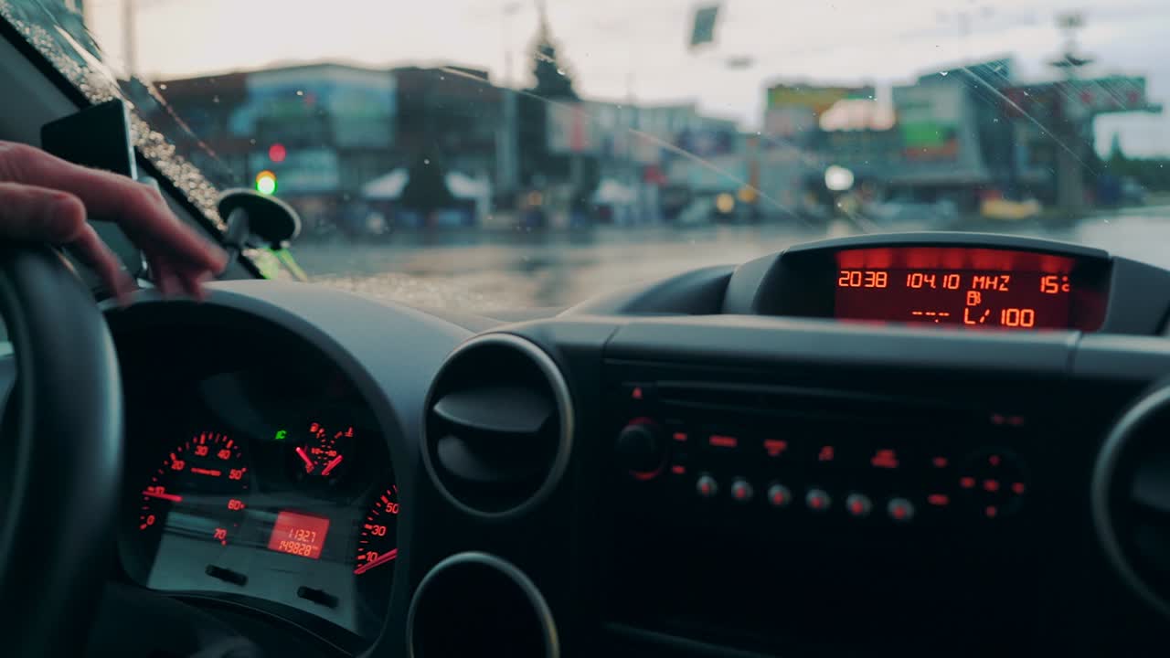 Driving a car in traffic jam in bad weather conditions. Hand of man driving a car. Close-up
