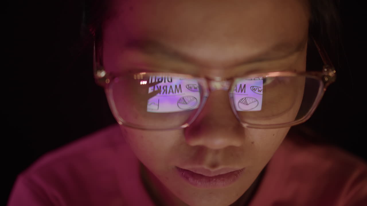 Woman with Reflection in Glasses Checking Tablet PC