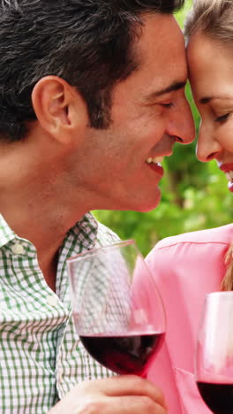 happy couple romancing while having a glass of wine in field