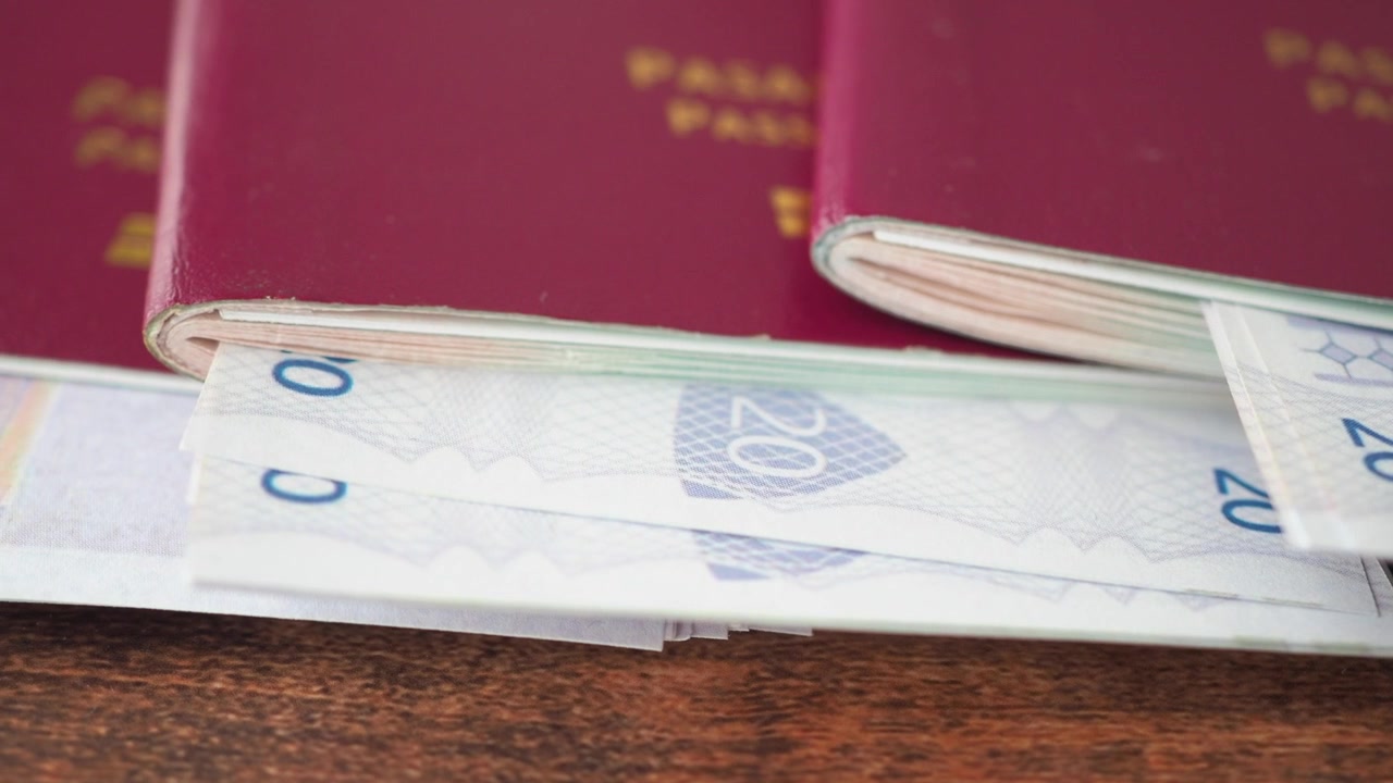Červené pasy s dvacetieurovými bankovkami na dřevěném stole